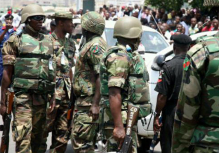Troops dressed as soldiers and traders engage in combat in the Abuja market